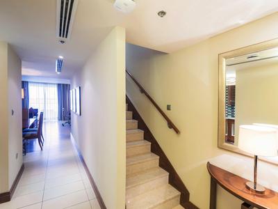 Korytarz z schodami i lampką stołową w jasnym pokoju hotelowym