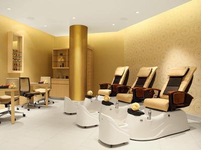Nowoczesny salon spa z fotelami do pedicure i relaksującą atmosferą w ciepłym świetle.