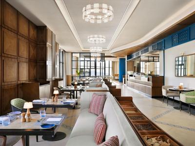 Elegantní hotelový lounge s pohovkami, křesly a dřevěnými stěnami v moderním designu.