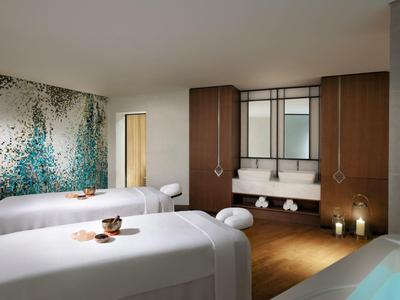 Moderně zařízený spa prostor se dvěma masážními lehátky a atmosférickým osvětlením.