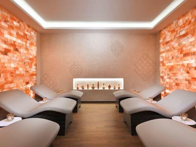 Relaxační místnost s pohodlnými lehátky a teple osvětlenými solnými panely.