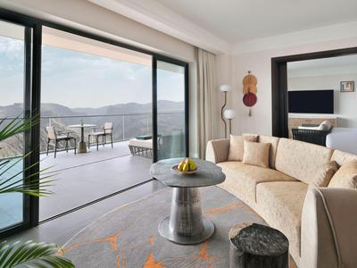 Moderně zařízený obývací pokoj s terasou a výhledem na hory v hotelu.