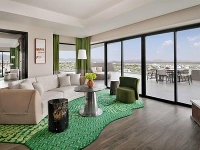 Moderní hotelový salonek s velkými okny a výhledem na terasu.