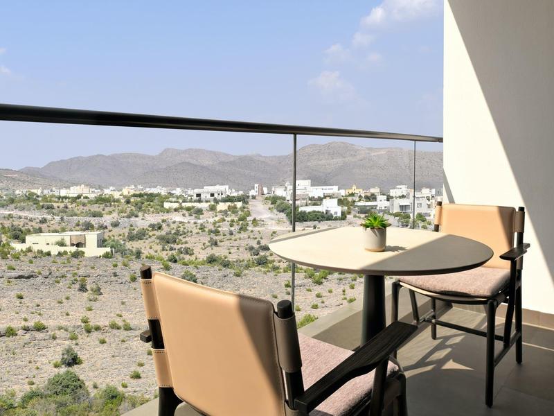 Příjemná hotelová restaurace s moderními židlemi a uměleckou nástěnnou malbou.