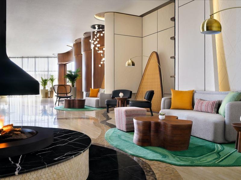 Moderně zařízená hotelová lounge s krbem, pohodlným posezením a dekorativními prvky.