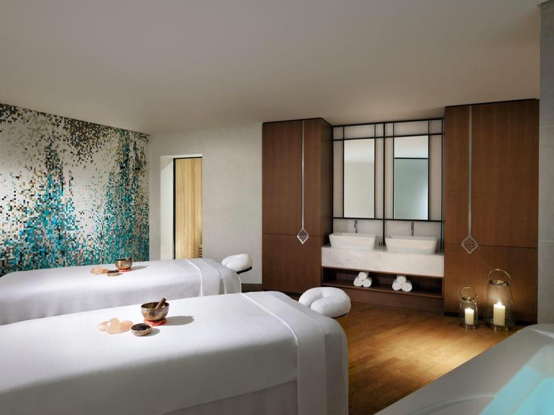 Moderně zařízený spa prostor se dvěma masážními lehátky a atmosférickým osvětlením.