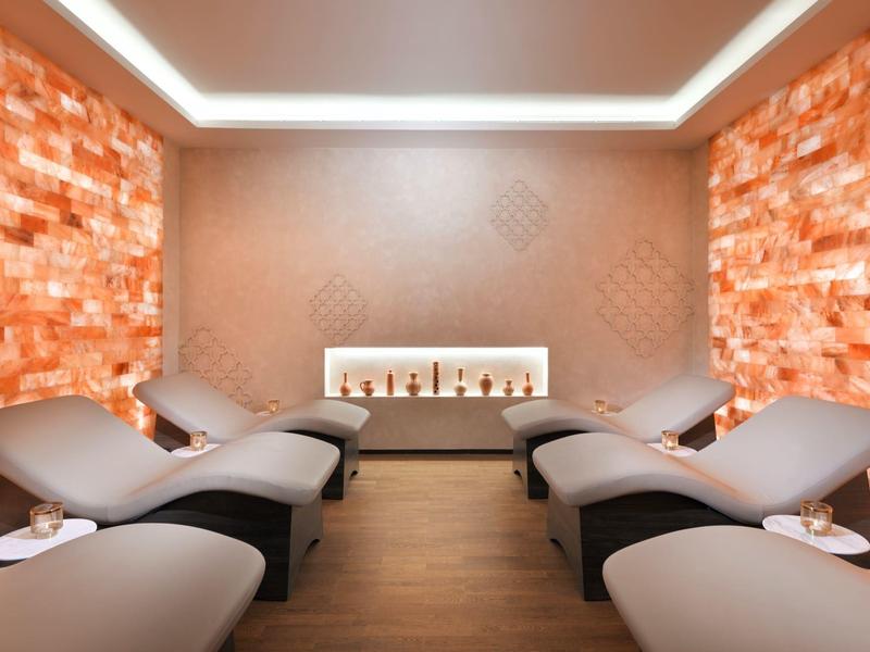 Relaxační místnost s pohodlnými lehátky a teple osvětlenými solnými panely.