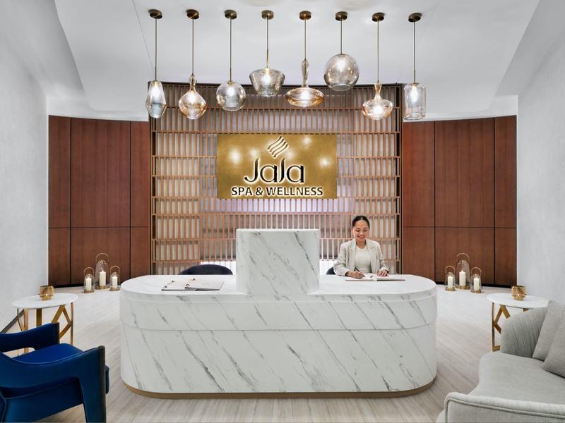 Moderní hotelová recepce s mramorovým pultem a elegantním dekoracemi.