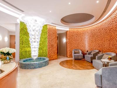 Moderne hotellobby met gebogen muren, zithoek en stijlvolle fontein.