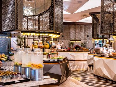 Elegantes Buffet mit verschiedenen Getränken und Speisen in modern gestaltetem Restaurant.