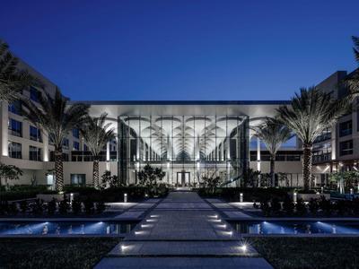 Modernes Hotel mit beleuchtetem Eingangsbereich und symmetrischer Architektur bei Nacht