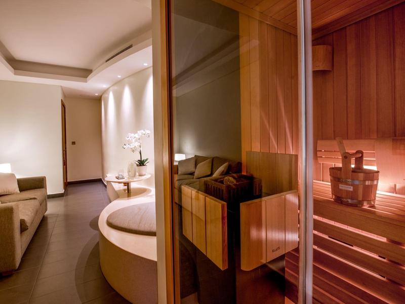 Luxe sauna met gezellige zitplaatsen en warm licht in een hotel.