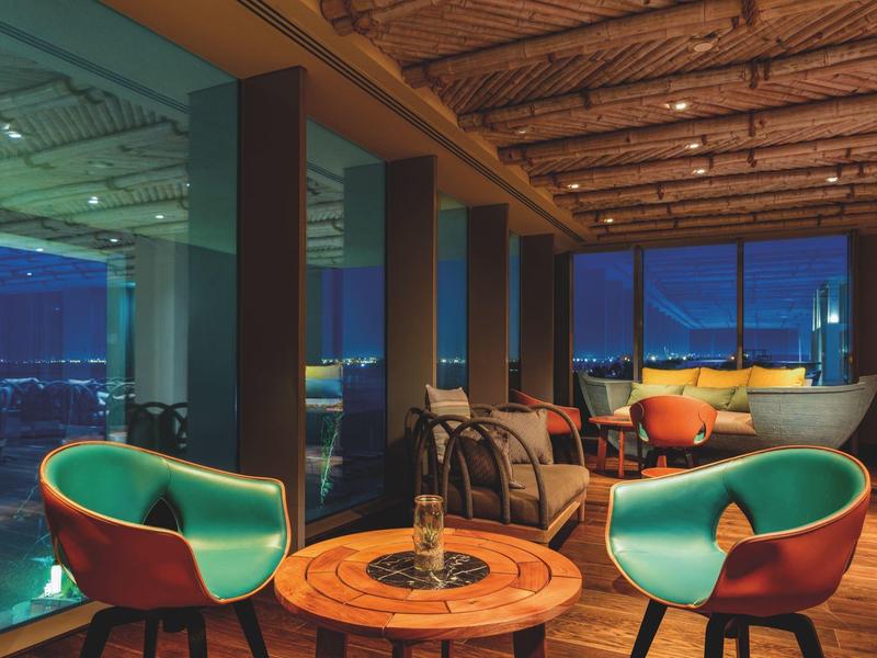 Moderne hotel lounge met comfortabele stoelen en uitzicht op de stad 's nachts.