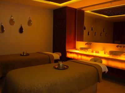 Pohodlná spa místnost se dvěma masážními stoly a teplým, atmosférickým osvětlením.