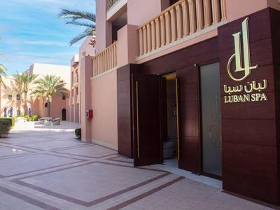 Vchod do Liban Spa v světlém, moderním hotelu s palmami a slunečným počasím.