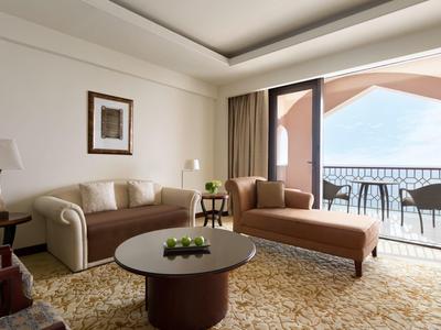 Elegantní obývací pokoj s pohovkou, lenoškou a balkonem s výhledem na moře.