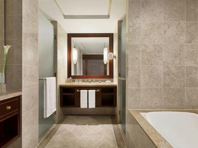 Světla, moderní koupelna s velkým zrcadlem, umyvadlem a vanou.