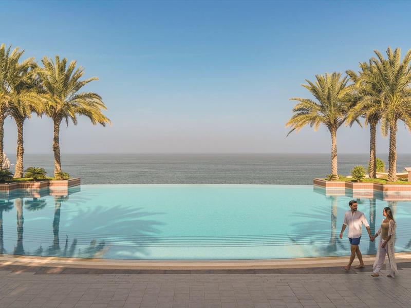 Infinity bazén s palmami a výhledem na moře za jasné oblohy