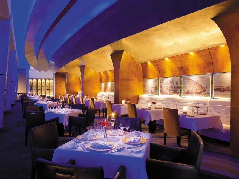 Elegantní hotelová restaurace s prostřenými stoly a teplým osvětlením večer.