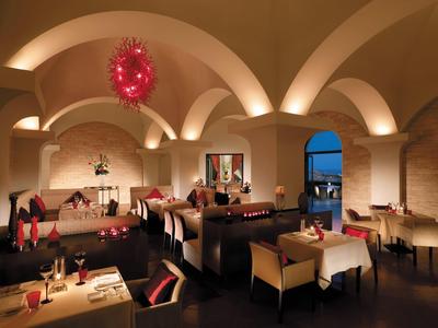 Restaurant élégant avec plafonds voûtés, tables dressées et ambiance chaleureuse au crépuscule.