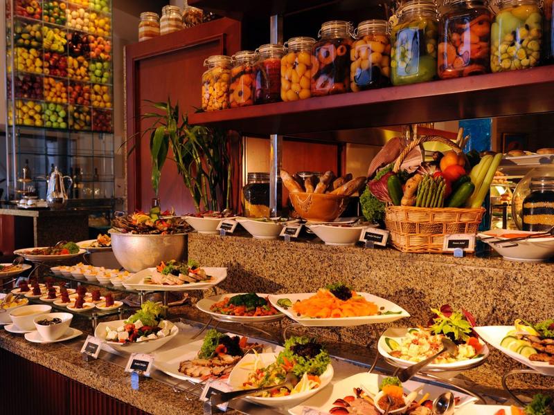 Buffet avec divers plats et bocaux colorés dans un restaurant élégant.