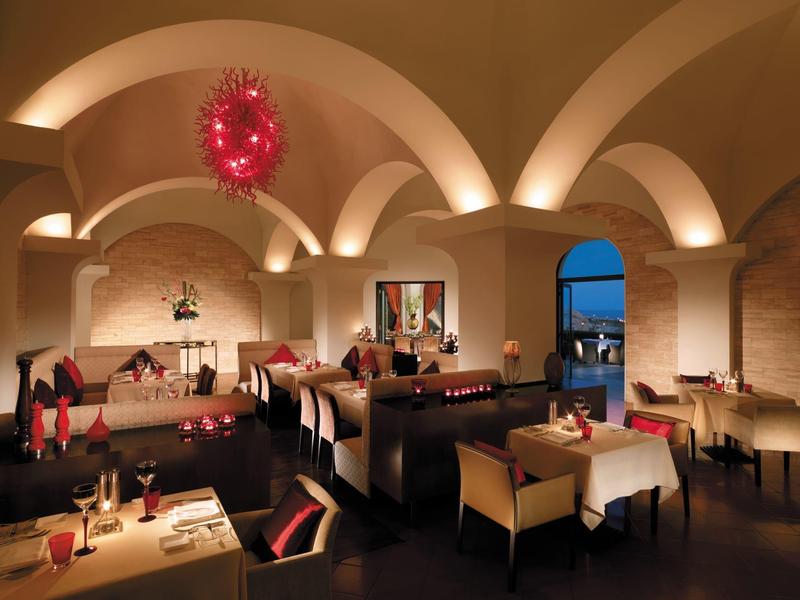 Restaurant élégant avec plafonds voûtés, tables dressées et ambiance chaleureuse au crépuscule.