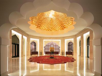 Luxurious hotel interior with ornate chandelier and decorated carpet.