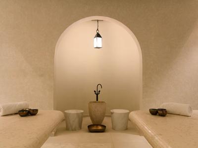 Sala de bienestar acogedora con camillas de masaje y luz cálida en un área de spa.