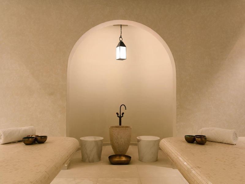 Sala de bienestar acogedora con camillas de masaje y luz cálida en un área de spa.