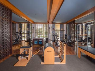 Modern gym with wooden equipment and large mirrors in a hotel