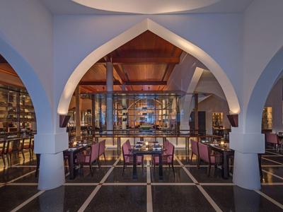 Elegantní hotelový lounge s oblouky, dřevěným nábytkem a teplým osvětlením.