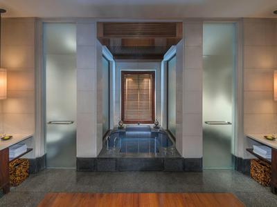 Moderní, stylová koupelna se symetrickým uspořádáním a tlumeným osvětlením.