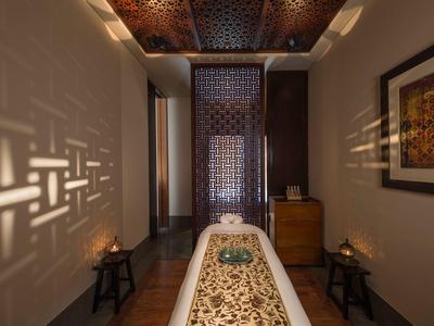 Léčební místnost s asijsky inspirovaným dekorativním stolem a teplým osvětlením ve spa.