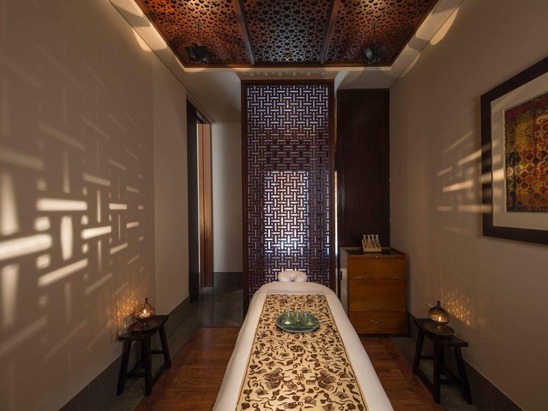 Léčební místnost s asijsky inspirovaným dekorativním stolem a teplým osvětlením ve spa.