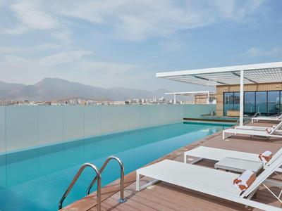 Moderner Pool auf der Dachterrasse mit Liegestühlen und Bergblick