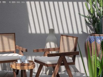 Gemütliche Sitzecke mit Holzmöbeln und Pflanzen, Sonnenlicht wirft Schattenmuster auf die Wand.