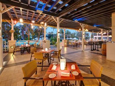 Gemütliche Außenrestaurant-Terrasse mit gedeckten Tischen und Beleuchtung am Abend.