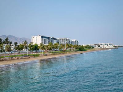 Strand mit Palmen und modernen Hotels entlang der Küste unter klarem Himmel