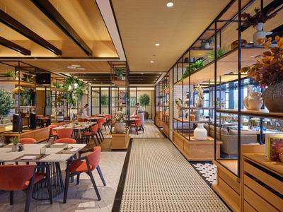 Restaurant d'hôtel aménagé de façon moderne avec mobilier en bois et couleurs sobres.