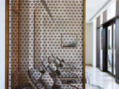 Un espace spa élégant avec deux chaises longues derrière un paravent en bois décoratif.