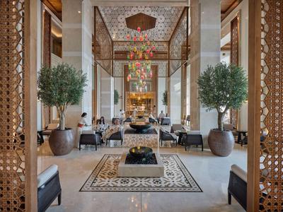 Eleganter Hotellobby-Bereich mit Marmorboden, Pflanzen und stilvollen Sitzgelegenheiten.