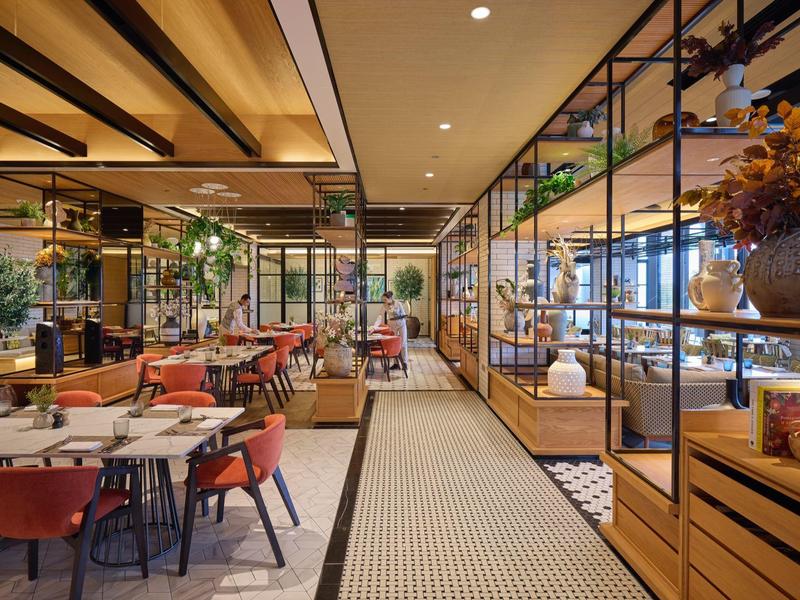 Restaurant d'hôtel aménagé de façon moderne avec mobilier en bois et couleurs sobres.