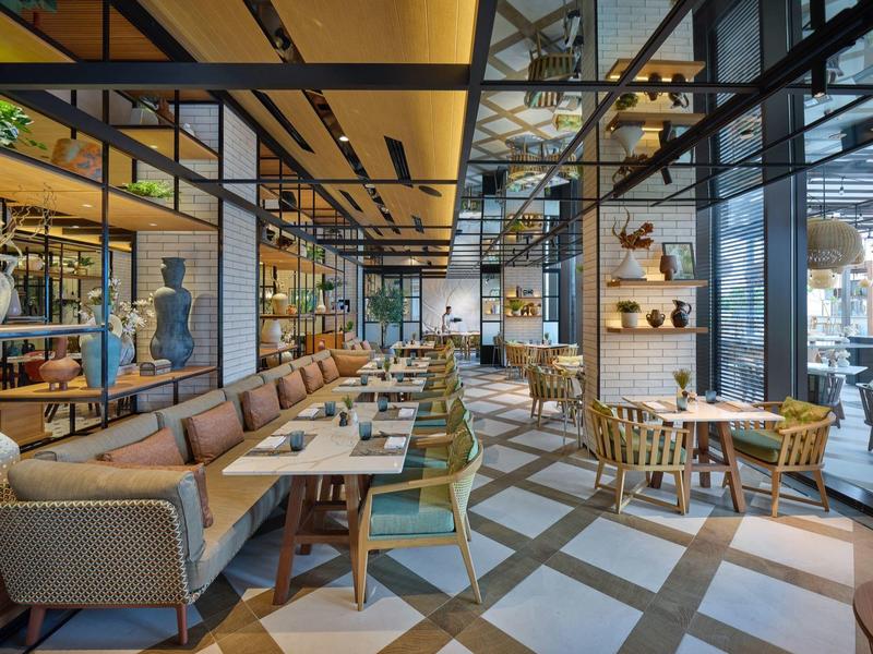 Restaurant moderne avec une longue zone de sièges et de grandes fenêtres.