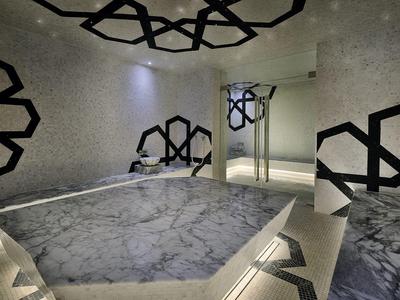 Moderní wellness místnost s mramorovou vanou a dekorativními černo-bílými vzory na stěnách.