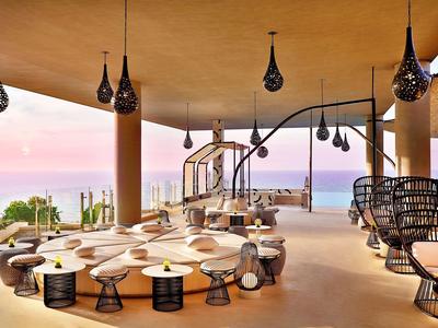 Moderní lounge s organicky tvarovaným sezením a otevřeným výhledem na moře a hory.