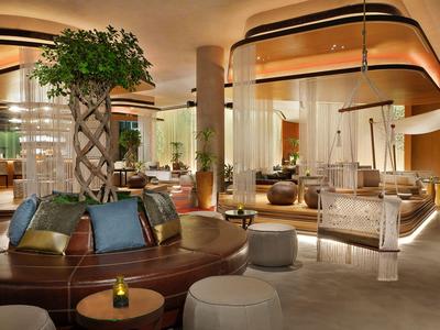 Espace lounge d'hôtel élégant avec sièges modernes et éclairage chaleureux.