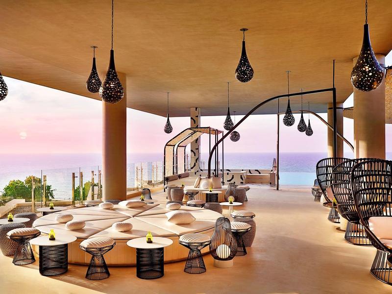 Moderní lounge s organicky tvarovaným sezením a otevřeným výhledem na moře a hory.