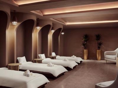 Elegantní wellness prostor s lehátky, měkkým osvětlením a klidnou atmosférou.