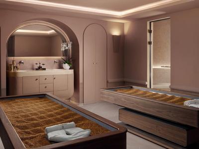 Moderní spa místnost se dvěma masážními stoly, jemným osvětlením a elegantním vybavením.