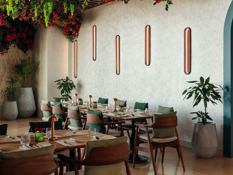 Moderní venkovní prostor hotelu s barem a posezením za denního světla.